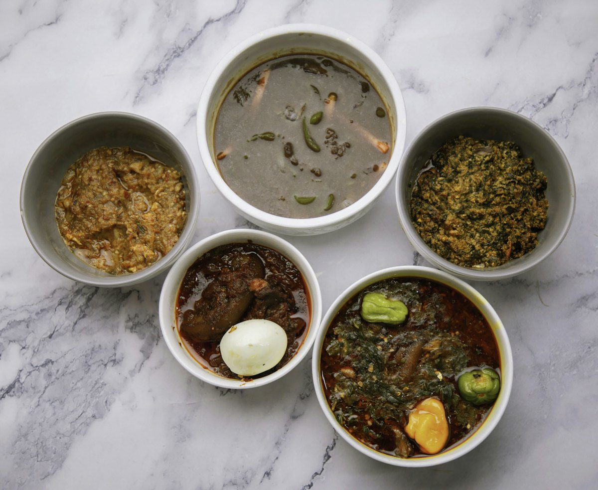 Bowls of Ghanaian soups and stews laid out together