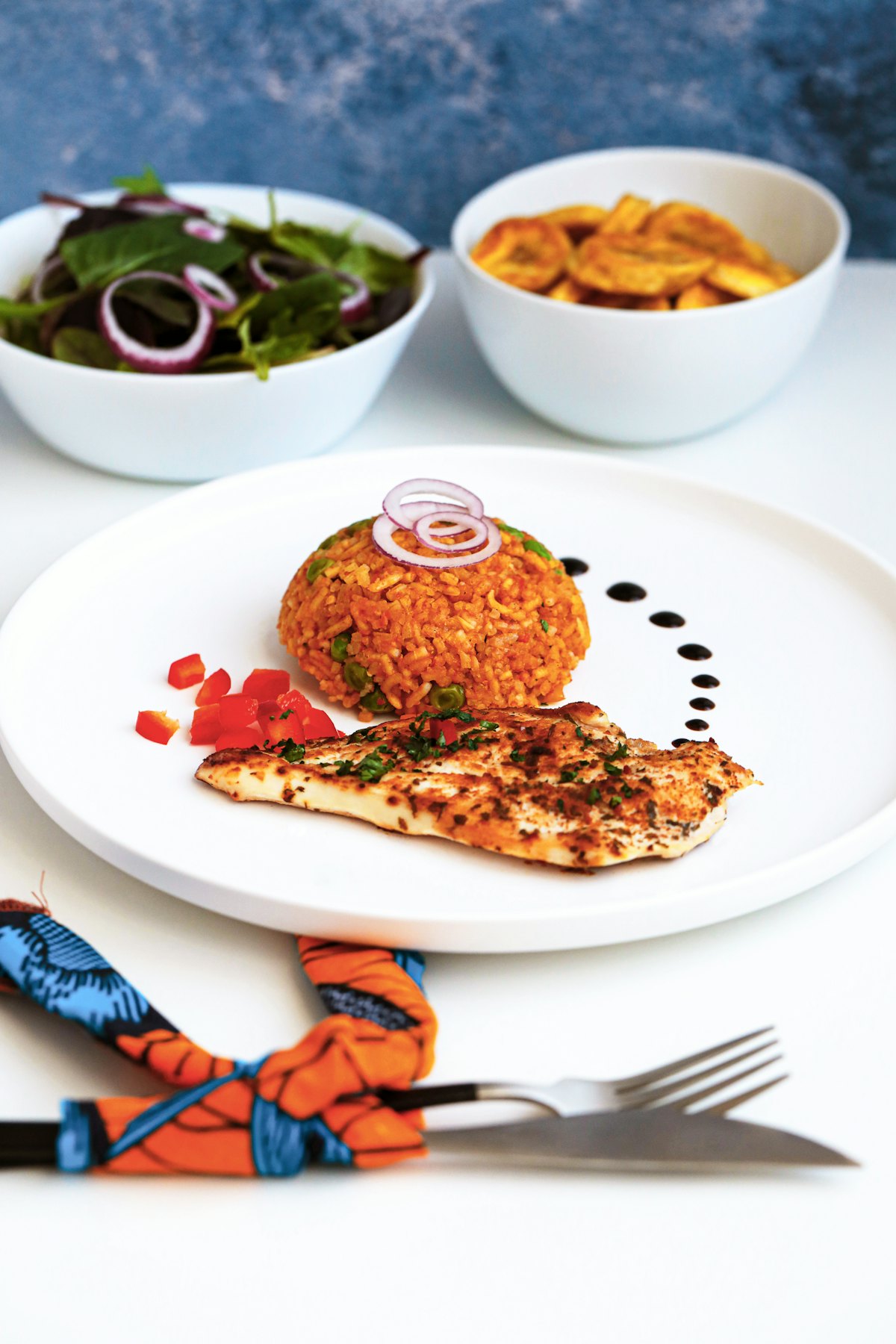Jollof rice with grilled chicken, fried plantain and salad